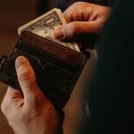 man pulling money out of his wallet, financial consequences of a DUI