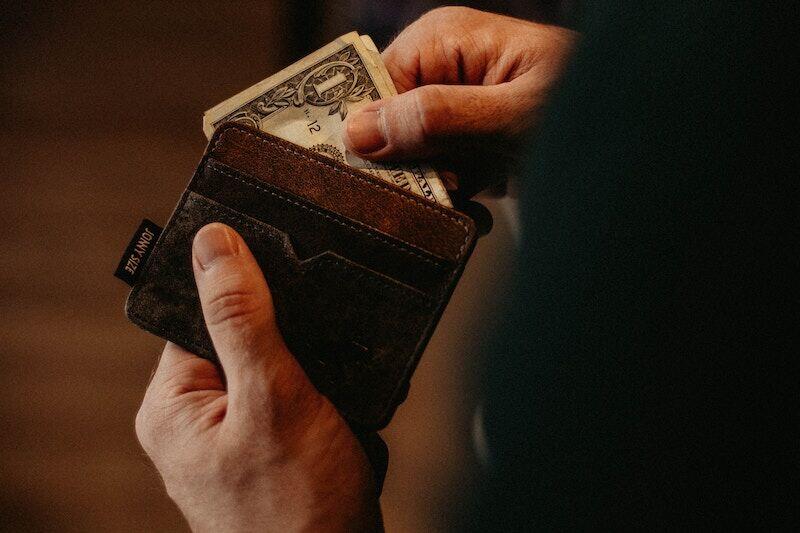 man pulling money out of his wallet, financial consequences of a DUI